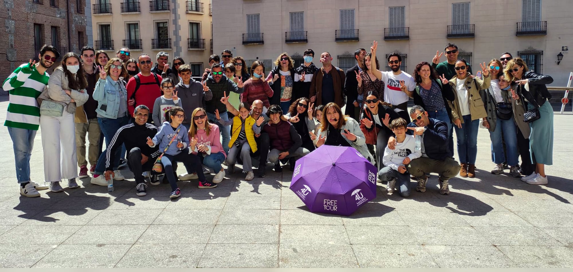 Grupo de viajeros al terminar un recorrido de 4U Madrid, con el paraguas morado en el suelo