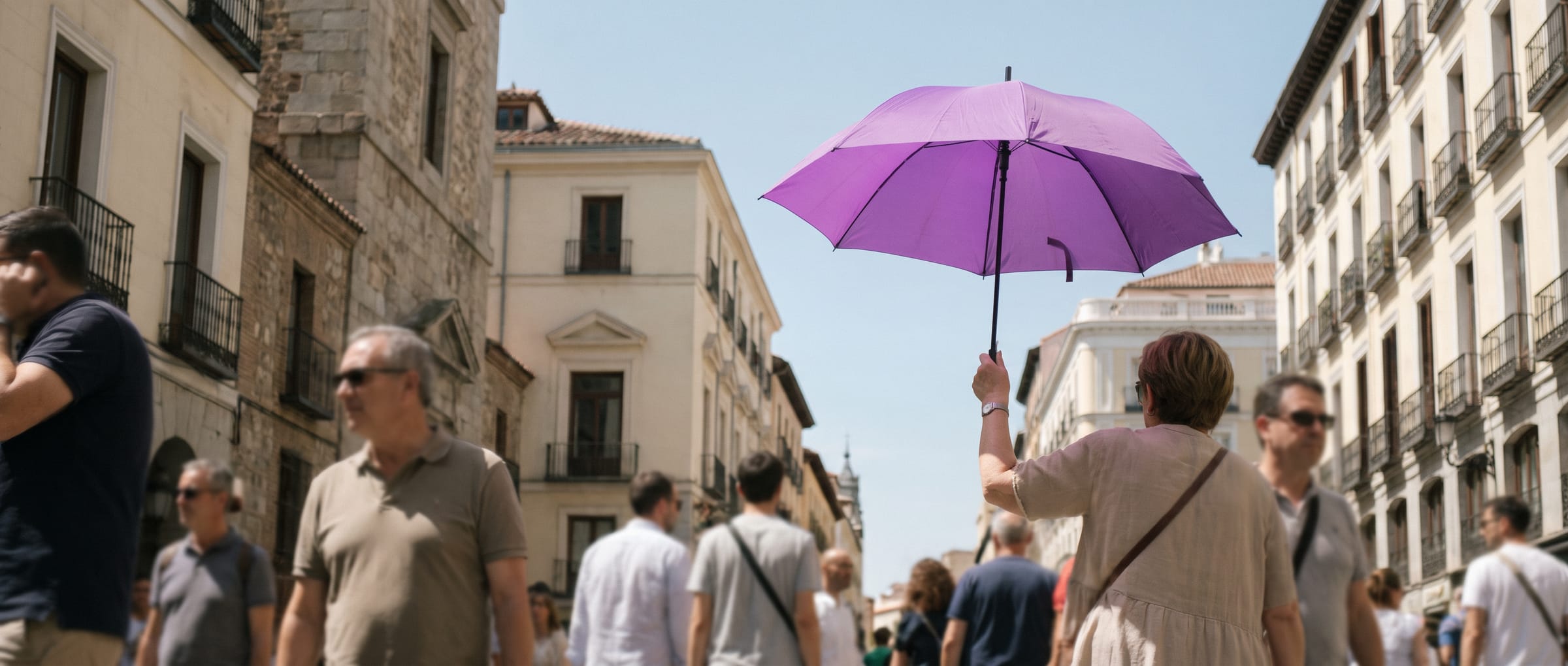 Paraguas morado de 4U Madrid en alto entre la gente en una calle de Madrid